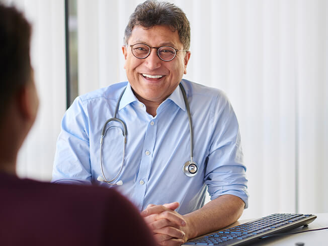 male physician smiling with female patient for web