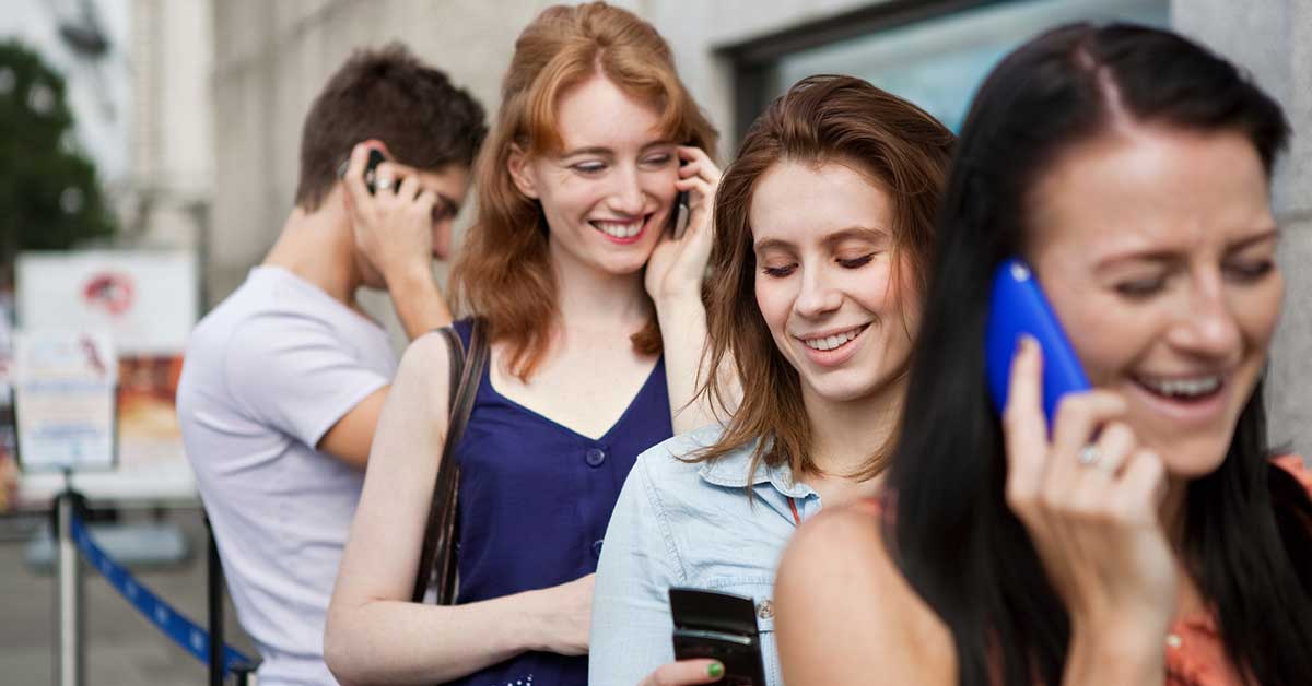 Group of friends using mobile smartphone outdoor