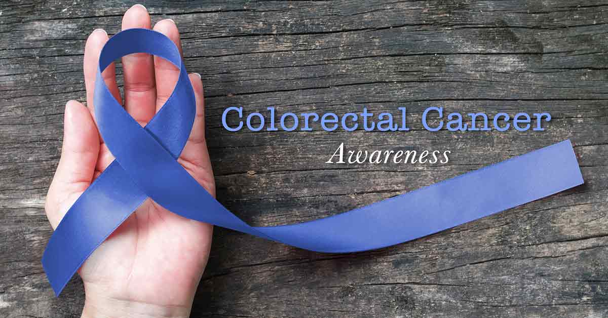 Colorectal or Colon cancer awareness dark blue ribbon on helping hand