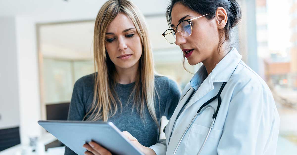 female doctor talking while explaining medical treatment with digital tablet to patient in the consultation