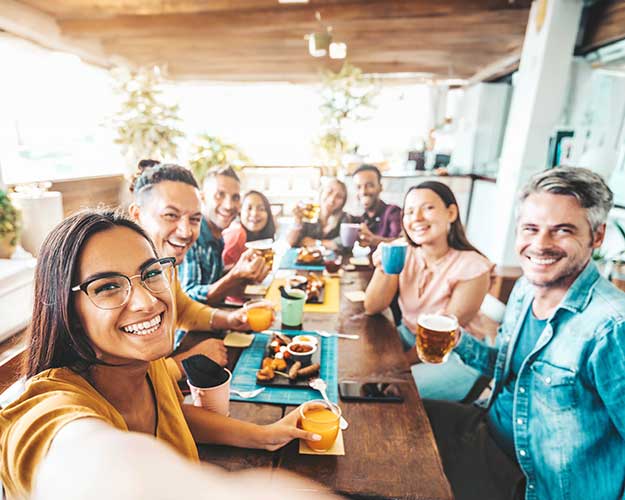 Multiracial group of friends having dinner party sitting at coffee bar table - Young people enjoying meal on morning brunch time